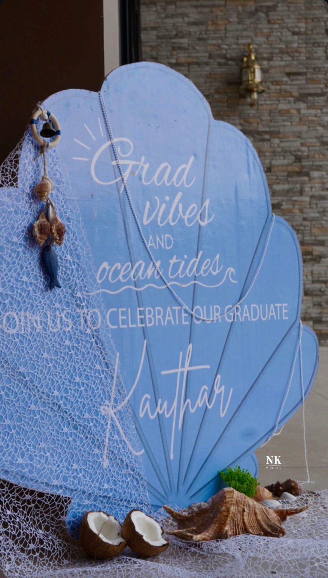Seashell graduation sign decorated with nets, shells and coconuts